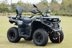 Gray ATV on a grassy field with trees in the background