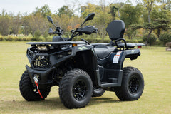 Black ATV parked on grass with trees in the background