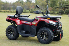 Red ATV on a grassy field with trees in the background