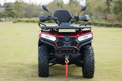 Red and black ATV on a grassy field with trees in the background